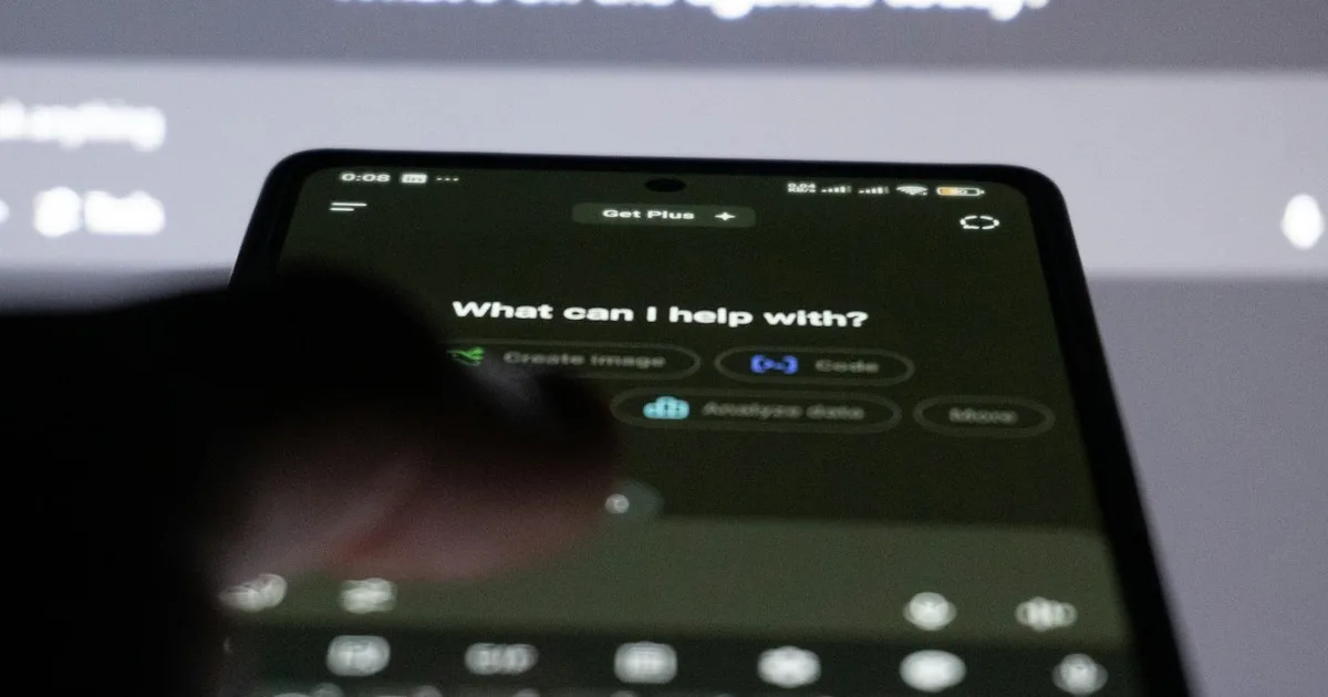 Smartphone displaying an AI chatbot interface with another AI assistant prompt visible in the blurred background — illustrating the multi-AI landscape of brand recommendation engines