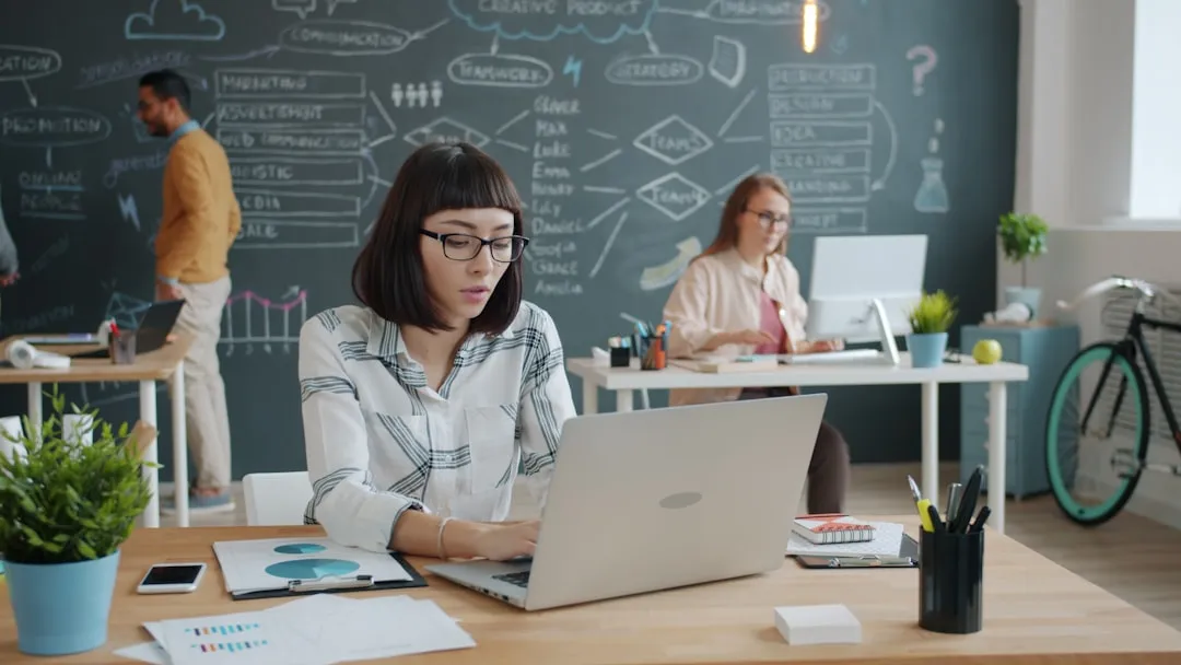 Marketing team working in a modern office with strategy planning on a chalkboard wall